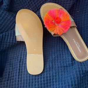 Kenneth Cole sandal with pink and orange Pom Pom in middle of sandal